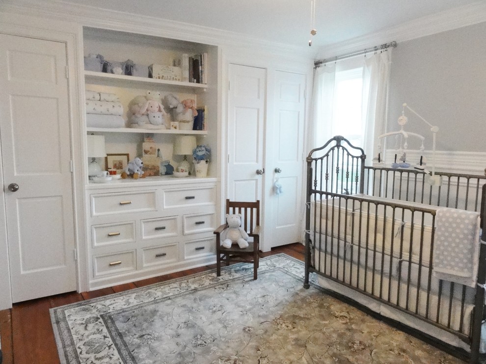 Cette photo montre une chambre de bébé neutre chic de taille moyenne avec un mur gris et un sol en bois brun.