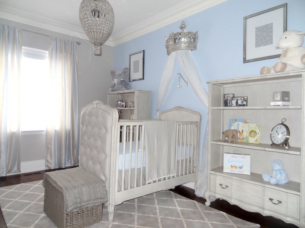 Small classic nursery for boys in Toronto with blue walls and dark hardwood flooring.