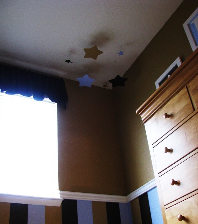 Cette photo montre une petite chambre de bébé garçon moderne avec un mur beige et moquette.
