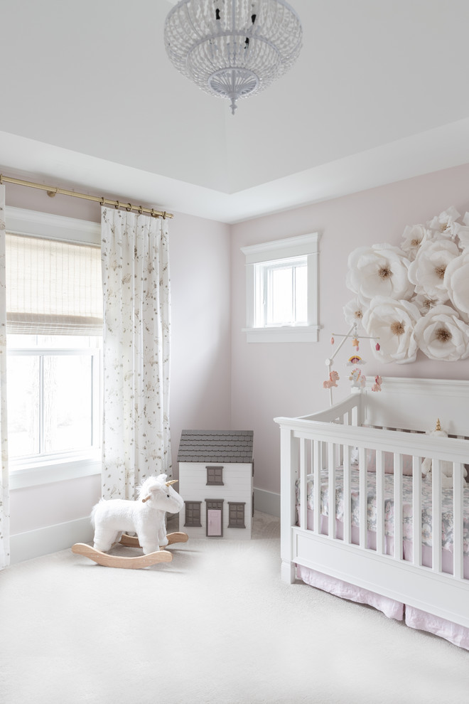Diseño de habitación de bebé niña de estilo de casa de campo grande con paredes rosas, moqueta y suelo blanco