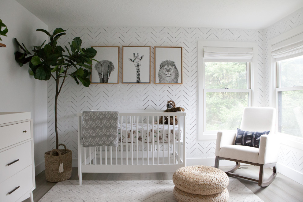Cette image montre une chambre de bébé neutre nordique avec un mur blanc, parquet clair et un sol gris.