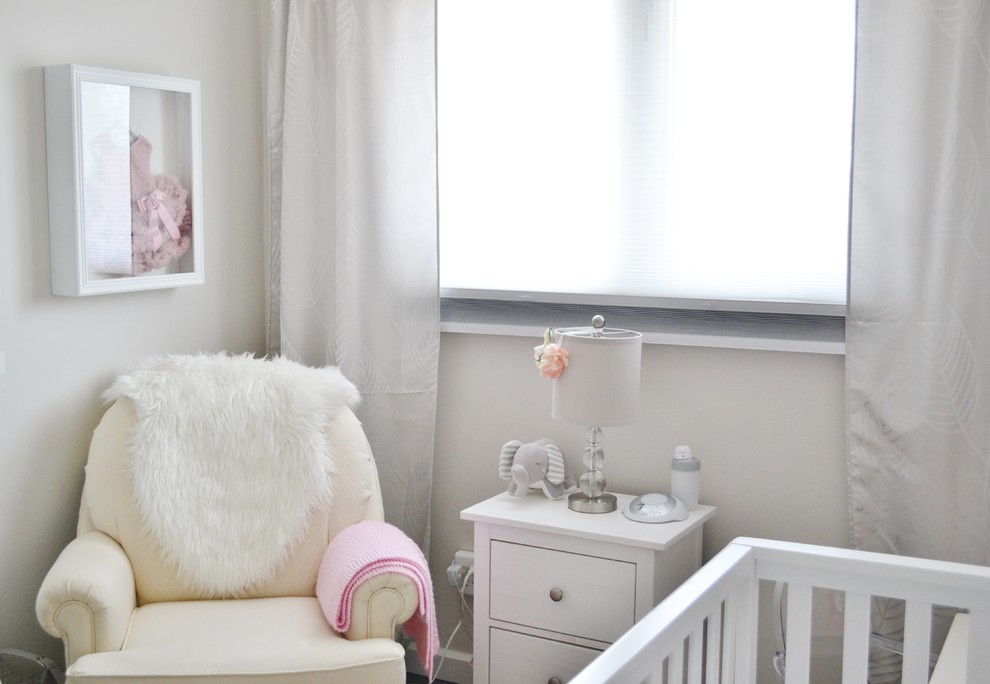 Cette image montre une petite chambre de bébé fille traditionnelle avec un mur beige et sol en stratifié.