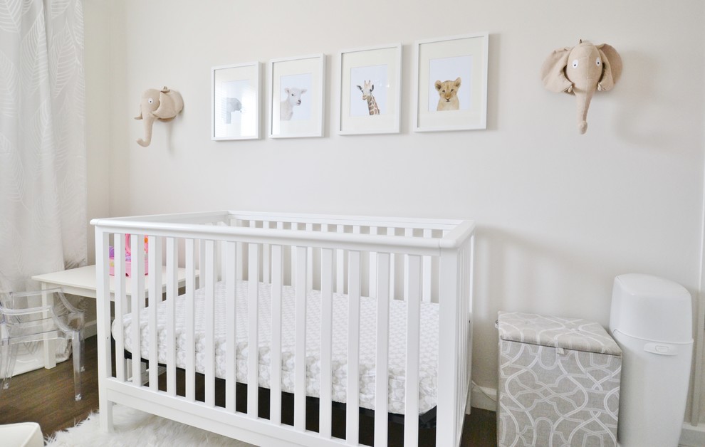 Small classic nursery for girls in Ottawa with beige walls and laminate floors.