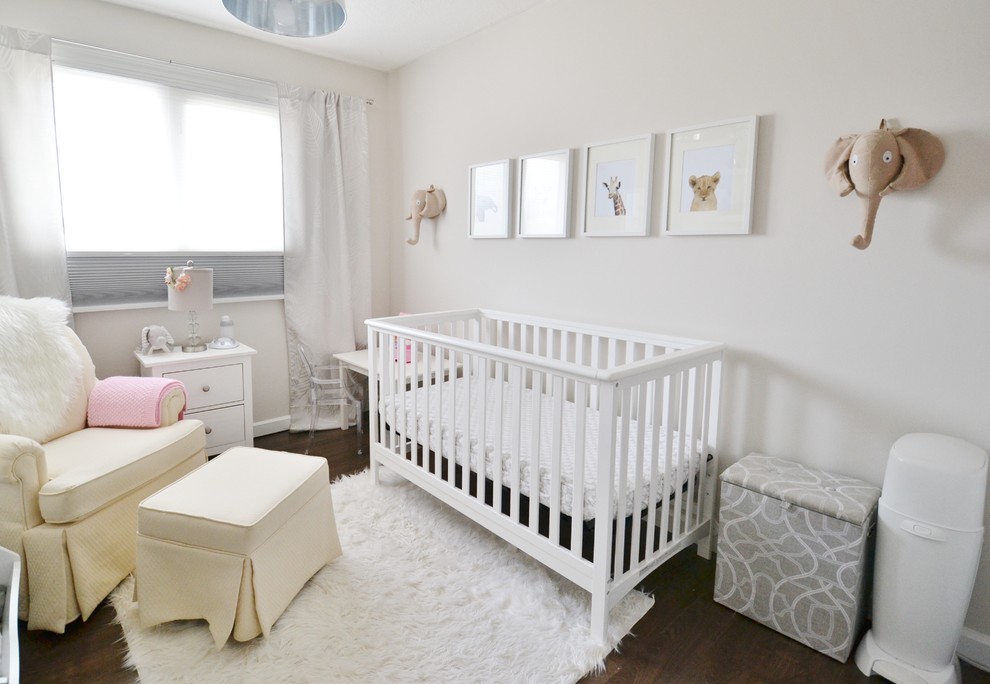 Réalisation d'une petite chambre de bébé fille tradition avec un mur beige et sol en stratifié.