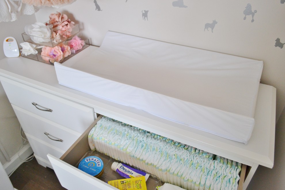 Foto de habitación de bebé niña clásica pequeña con paredes beige y suelo laminado