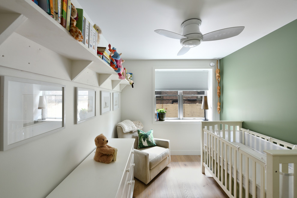 Idee per una cameretta per neonati neutra tradizionale di medie dimensioni con pareti verdi, pavimento in legno massello medio e pavimento beige