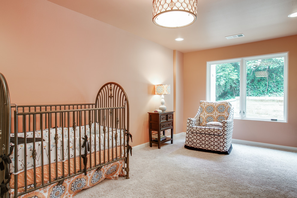 Cette photo montre une grande chambre de bébé fille chic avec un mur orange et moquette.