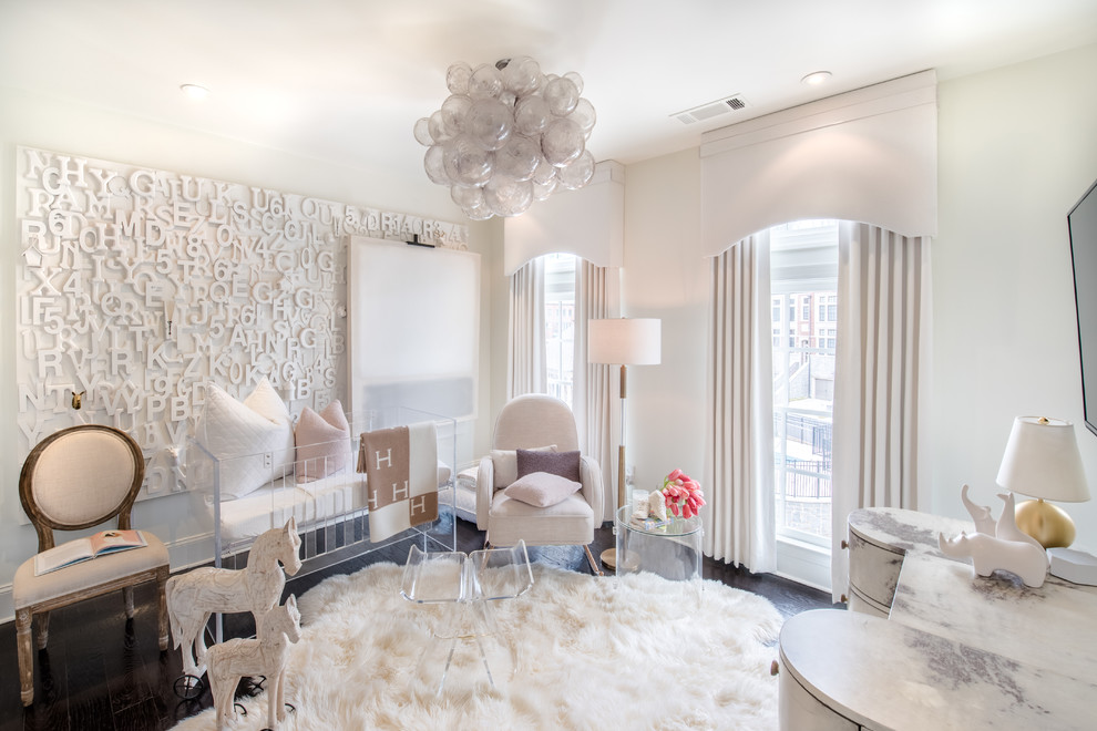 Cette photo montre une chambre de bébé tendance avec un mur blanc, parquet foncé et un sol marron.