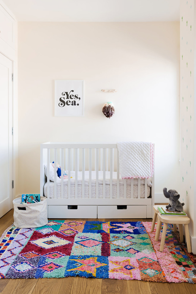 Design ideas for a medium sized eclectic gender neutral nursery in New York with white walls.