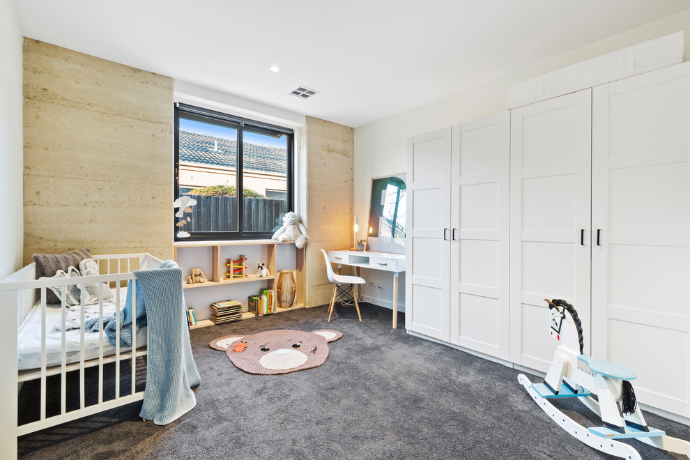 Foto di una cameretta per neonati neutra contemporanea con pareti bianche, moquette e pavimento grigio