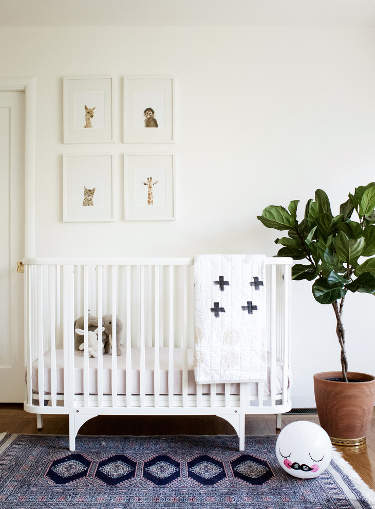 Свежая идея для дизайна: нейтральная комната для малыша в скандинавском стиле с белыми стенами и паркетным полом среднего тона - отличное фото интерьера
