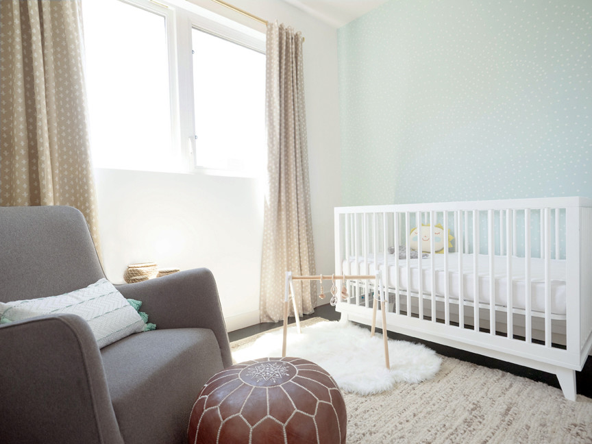 Ejemplo de habitación de bebé neutra moderna de tamaño medio con suelo de madera oscura, suelo marrón y paredes blancas