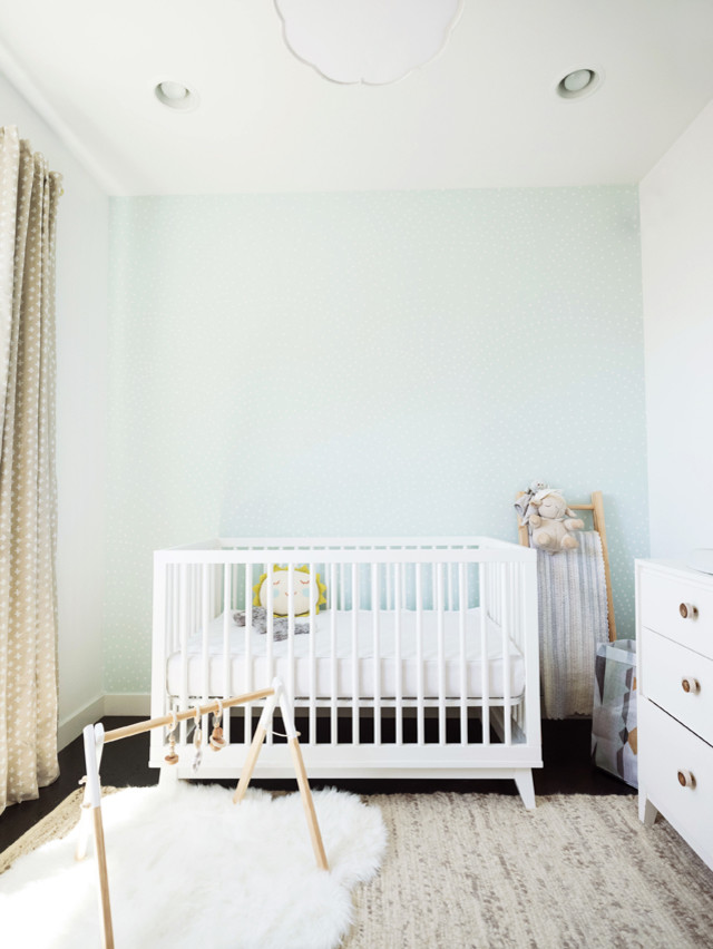 Diseño de habitación de bebé neutra minimalista de tamaño medio con paredes blancas, suelo de madera oscura y suelo marrón