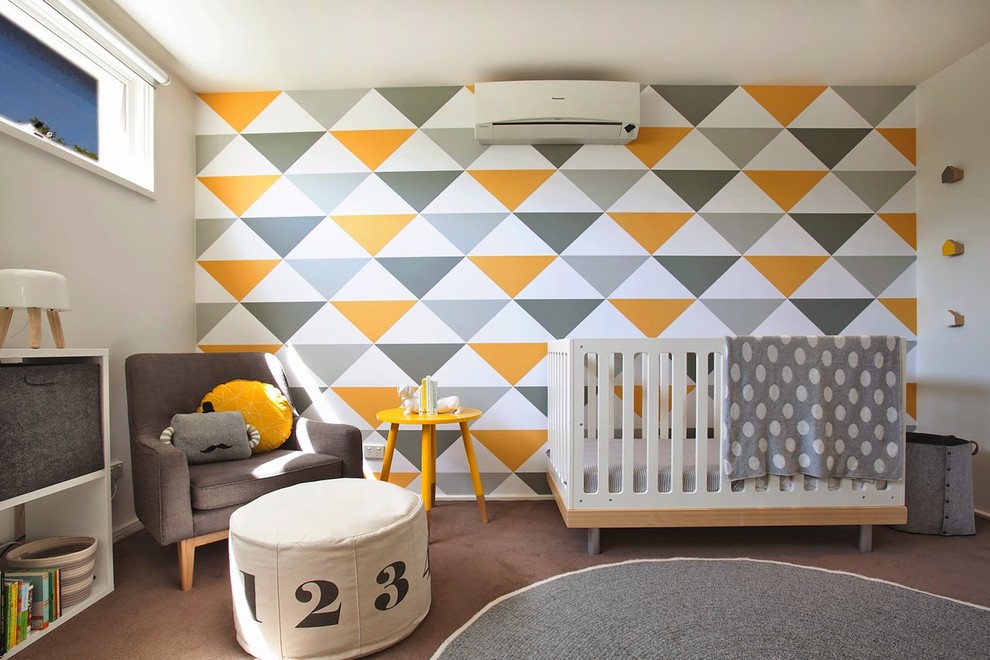Modern inredning av ett könsneutralt babyrum, med flerfärgade väggar, heltäckningsmatta och brunt golv