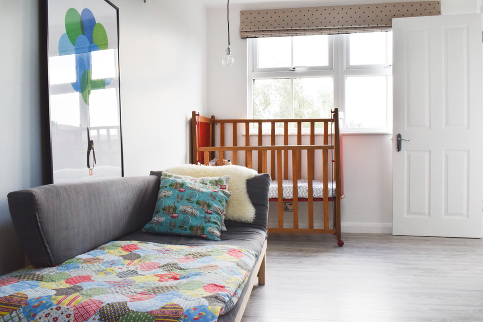 Пример оригинального дизайна: нейтральная комната для малыша среднего размера в современном стиле с белыми стенами и полом из винила