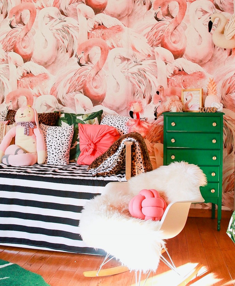 Idéer för ett exotiskt babyrum, med rosa väggar, mellanmörkt trägolv och brunt golv