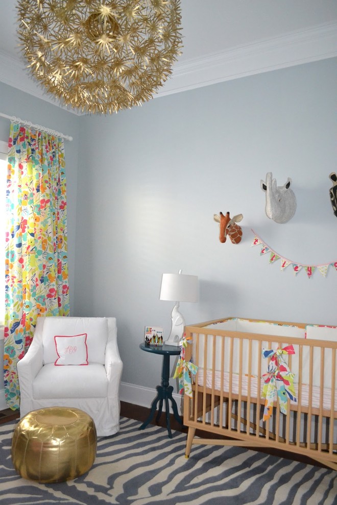 Imagen de habitación de bebé niña clásica con paredes grises y suelo de madera oscura