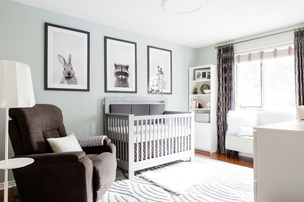 Imagen de habitación de bebé niño tradicional renovada de tamaño medio con paredes verdes y suelo de madera clara