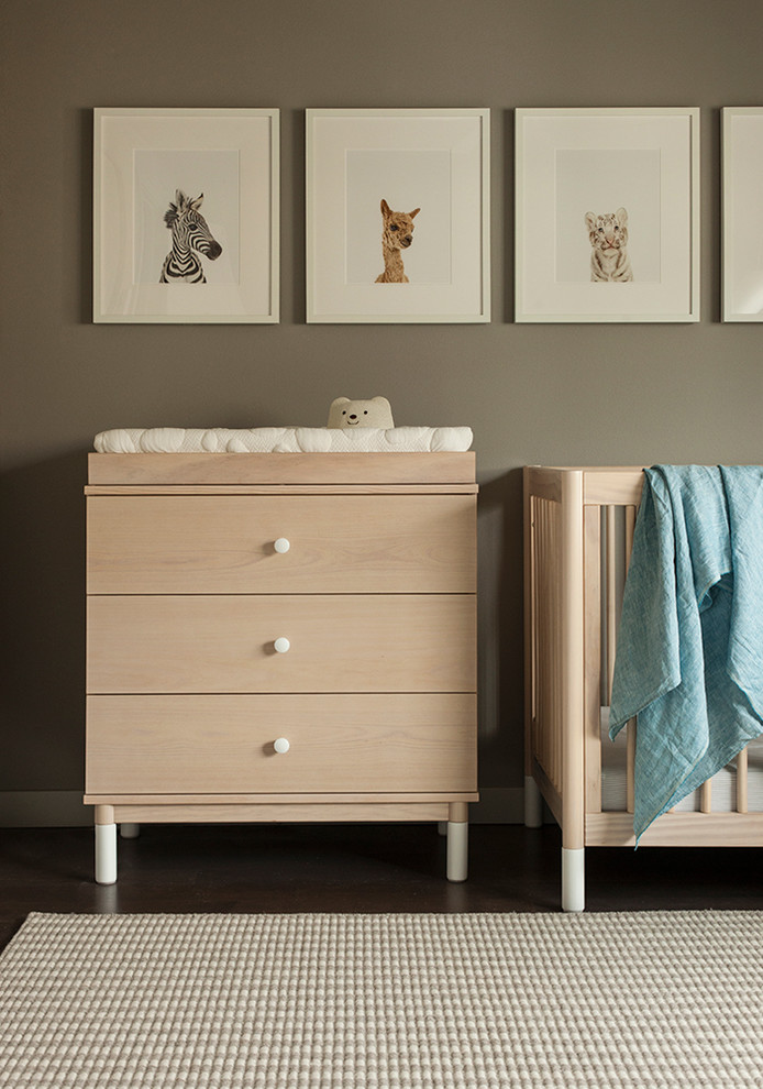 Diseño de habitación de bebé neutra moderna pequeña con paredes grises, moqueta y suelo gris