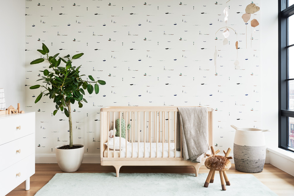 Modelo de habitación de bebé neutra nórdica con paredes multicolor y suelo de madera clara
