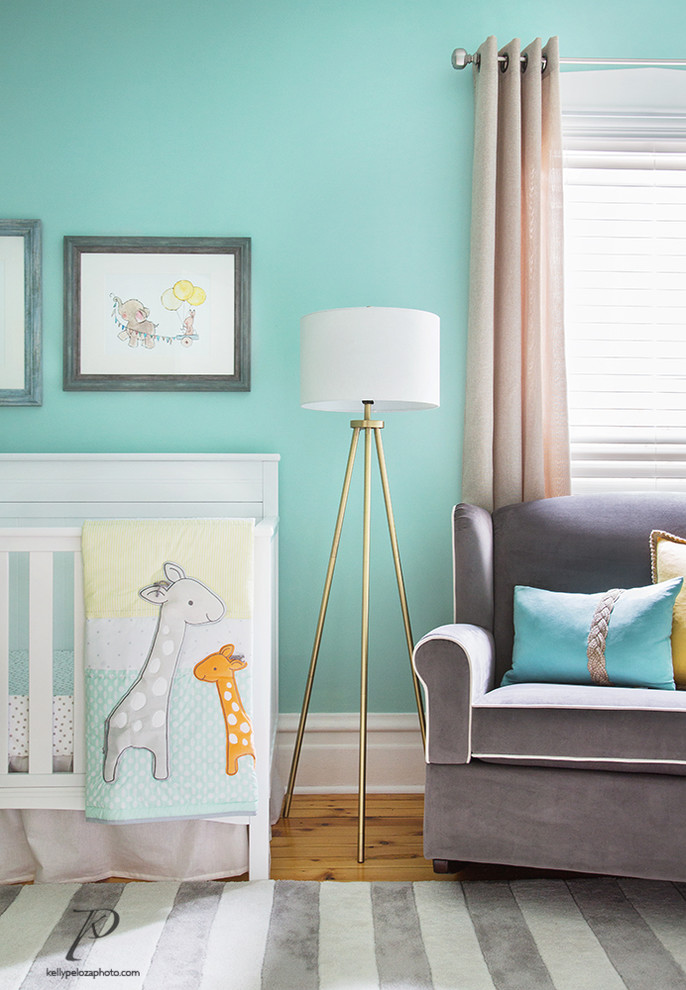 Imagen de habitación de bebé neutra pequeña con paredes verdes, suelo de madera clara y suelo amarillo