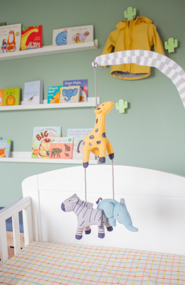 Idée de décoration pour une chambre de bébé neutre design de taille moyenne avec un mur vert, moquette et un sol beige.