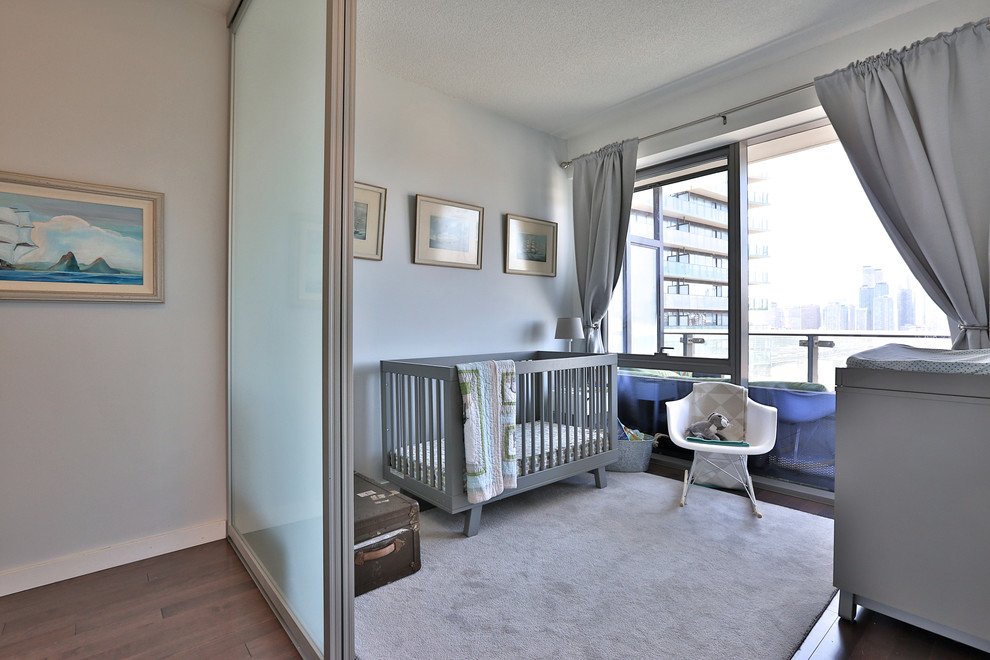 Aménagement d'une chambre de bébé neutre éclectique de taille moyenne avec un mur bleu et un sol en bois brun.