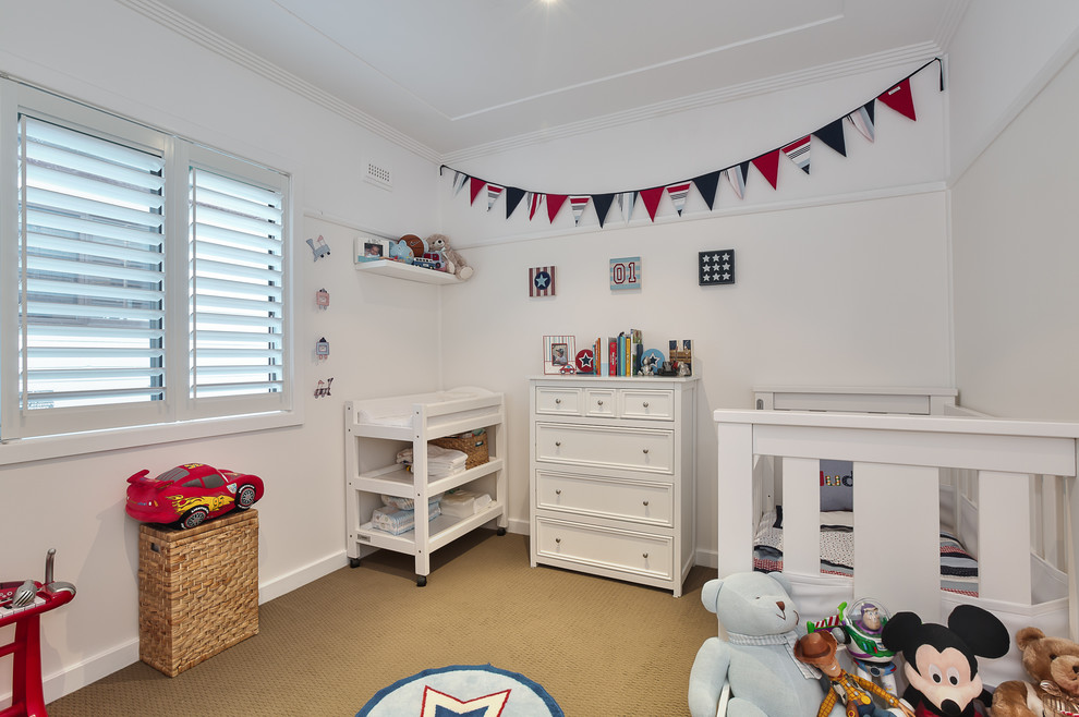 На фото: комната для малыша среднего размера в классическом стиле с белыми стенами, ковровым покрытием и коричневым полом для мальчика с