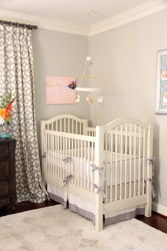 Imagen de habitación de bebé clásica con paredes grises y suelo de madera oscura