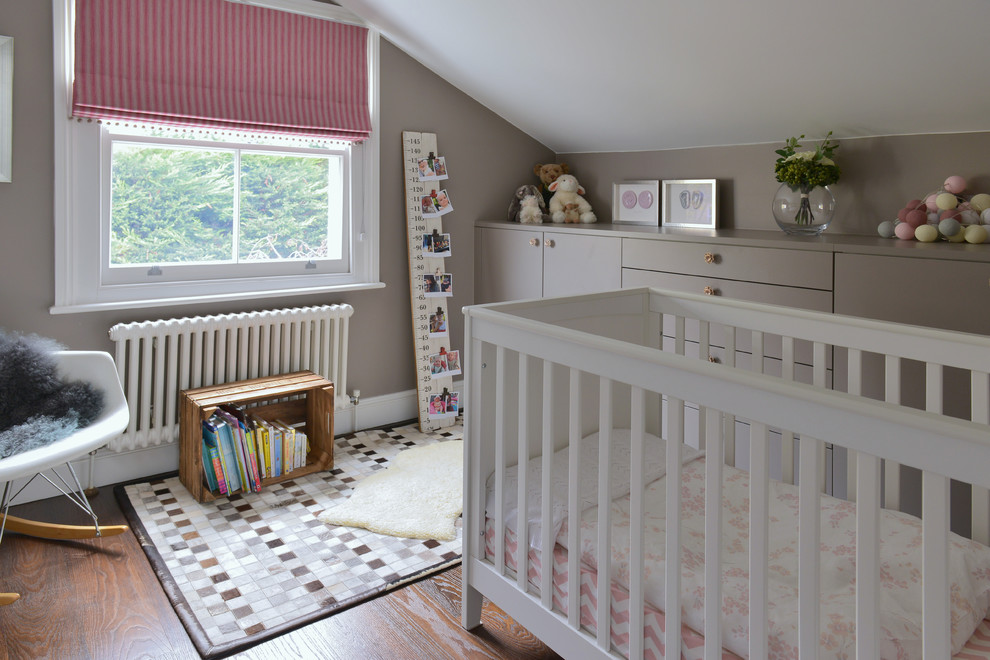 Imagen de habitación de bebé contemporánea de tamaño medio con paredes grises y suelo de madera en tonos medios