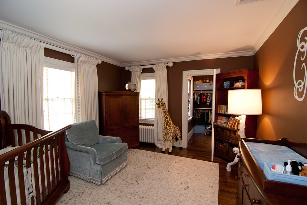 Imagen de habitación de bebé clásica con paredes marrones y suelo de madera oscura