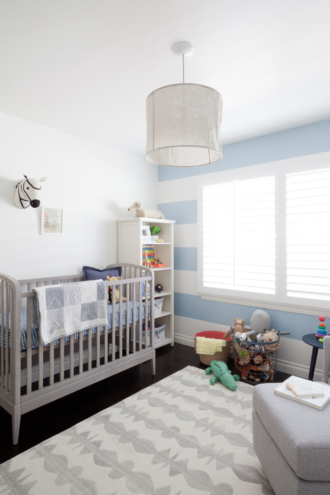 На фото: комната для малыша среднего размера в стиле неоклассика (современная классика) с синими стенами и темным паркетным полом для мальчика с
