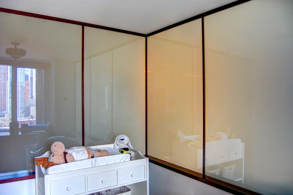 Cette image montre une chambre de bébé neutre design de taille moyenne avec un mur blanc.