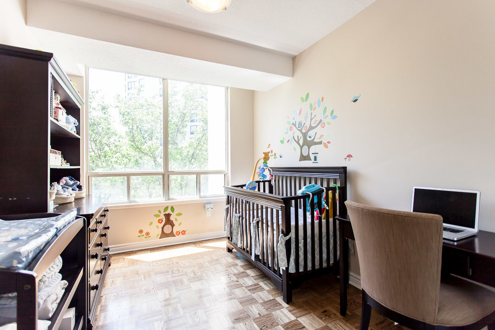 Cette photo montre une petite chambre de bébé tendance avec un mur beige et un sol marron.