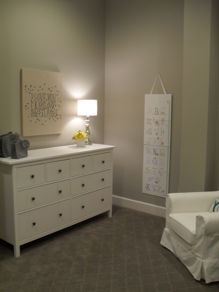 Modelo de habitación de bebé neutra actual de tamaño medio con paredes grises y moqueta