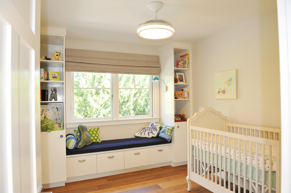 Idée de décoration pour une chambre de bébé neutre design de taille moyenne avec un mur gris, un sol en bois brun et un sol marron.