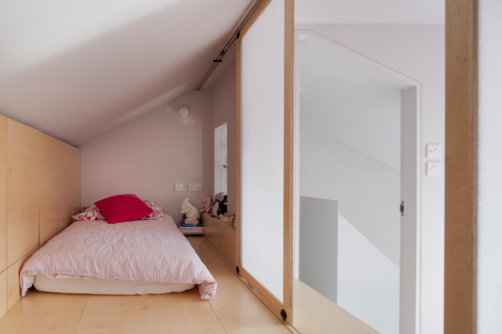 ロンドンにある高級な小さなコンテンポラリースタイルのおしゃれな赤ちゃん部屋 (グレーの壁、塗装フローリング、男女兼用、ピンクの床、パネル壁) の写真