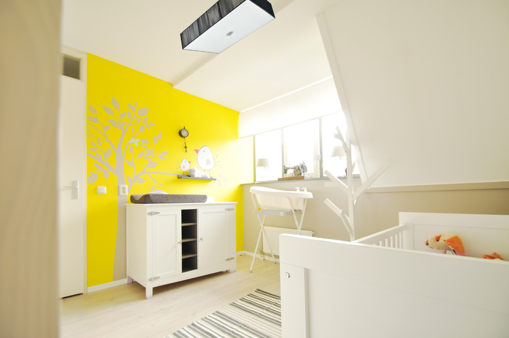 Idéer för ett modernt könsneutralt babyrum, med gula väggar, ljust trägolv och beiget golv