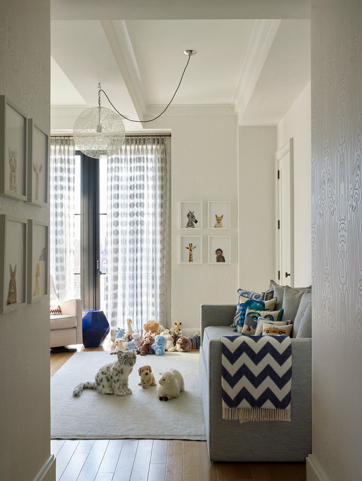 Traditional nursery in New York with white walls, light hardwood flooring and feature lighting.