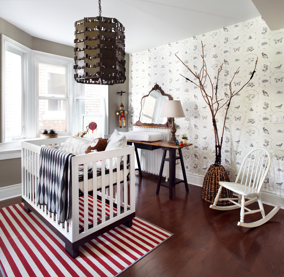 Mid-sized trendy gender-neutral dark wood floor nursery photo in Toronto with gray walls