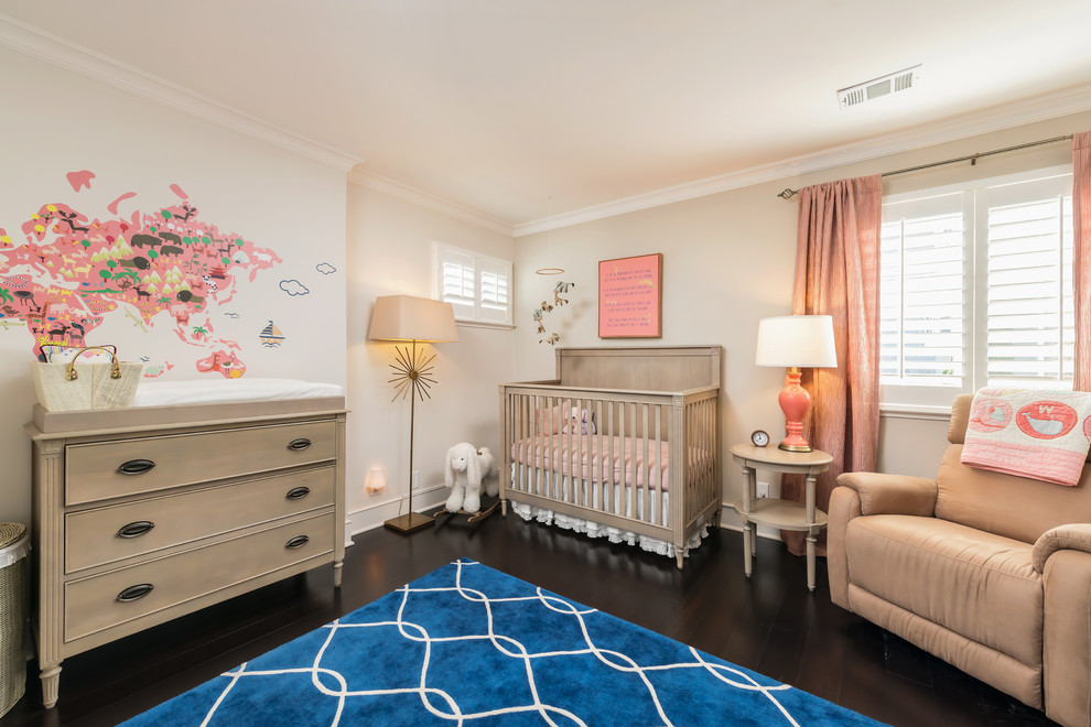 Imagen de habitación de bebé niña tradicional de tamaño medio con paredes beige y suelo de madera oscura