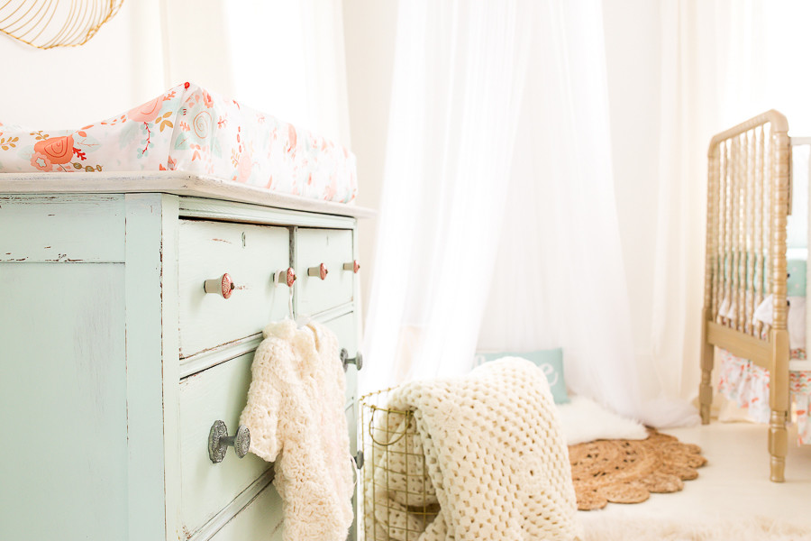 Immagine di una cameretta per neonata stile shabby di medie dimensioni con pareti bianche e pavimento in legno verniciato