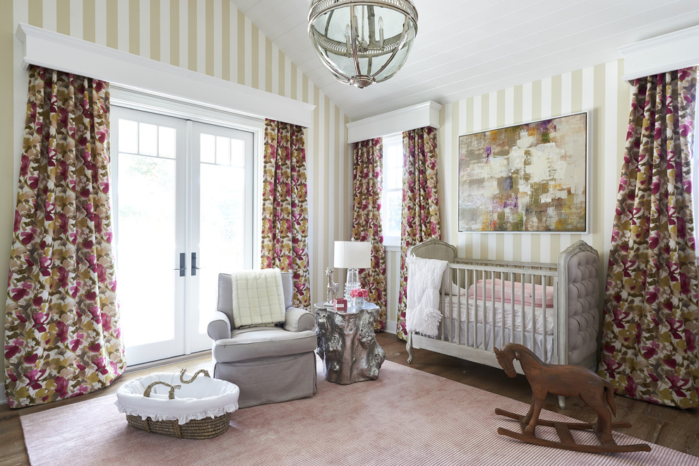 This is an example of a large classic nursery for girls in San Diego with multi-coloured walls and light hardwood flooring.