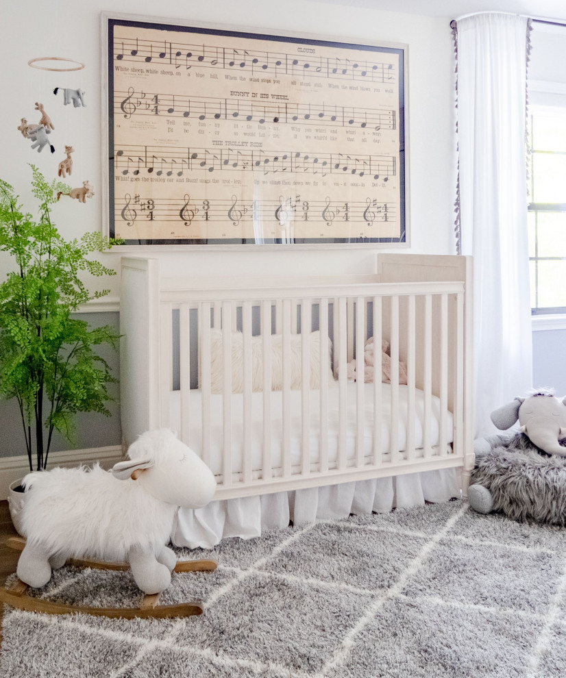 Imagen de habitación de bebé neutra campestre de tamaño medio con paredes grises, suelo de madera en tonos medios y suelo marrón
