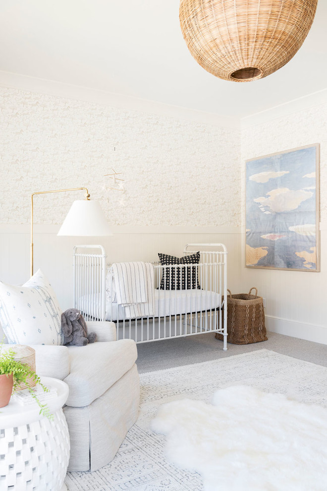 Réalisation d'une grande chambre de bébé fille marine avec un mur blanc, moquette et un sol gris.