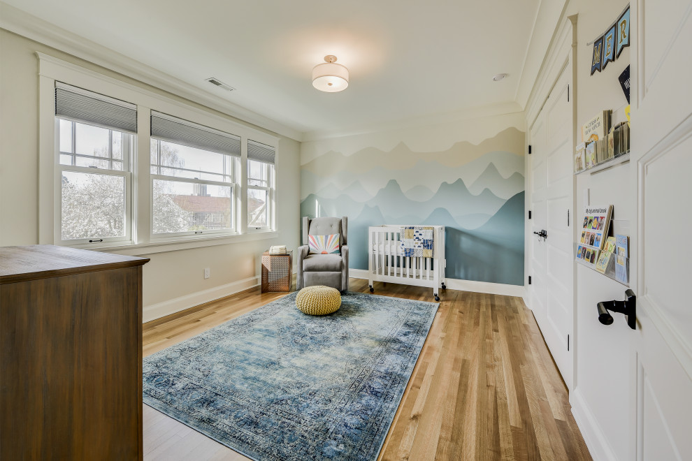 Foto de habitación de bebé neutra de estilo americano de tamaño medio con paredes blancas y suelo de madera clara