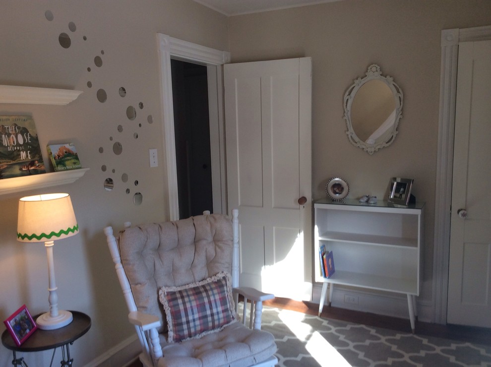 Diseño de habitación de bebé neutra clásica renovada de tamaño medio con paredes beige y suelo de madera en tonos medios