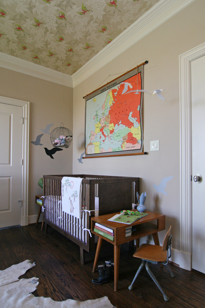 Cette image montre une chambre de bébé neutre bohème avec un mur beige et parquet foncé.