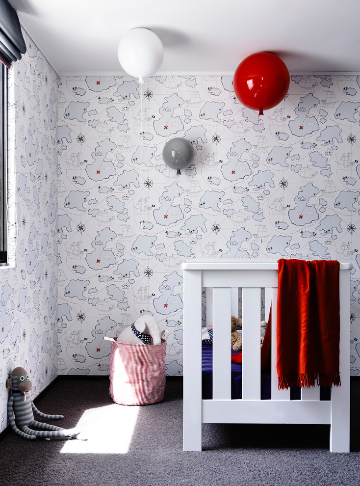 Inredning av ett modernt könsneutralt babyrum, med flerfärgade väggar, heltäckningsmatta och grått golv