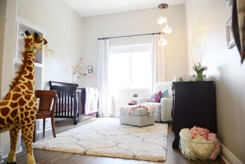 Esempio di una cameretta per neonata chic di medie dimensioni con pareti grigie, pavimento in legno massello medio e pavimento marrone